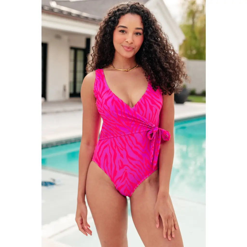 Bold neon animal print one-piece swimsuit with wrap tie plunging neckline and cheeky fit. Perfect plus friendly