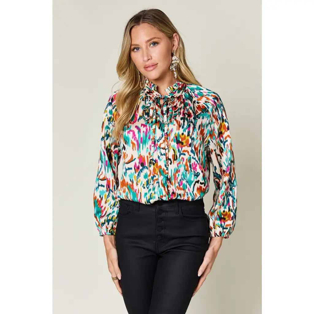 Chic abstract print tunic blouse with flowy fit and ruffled neckline. Sizes SM–3XL. Perfect plus size office top