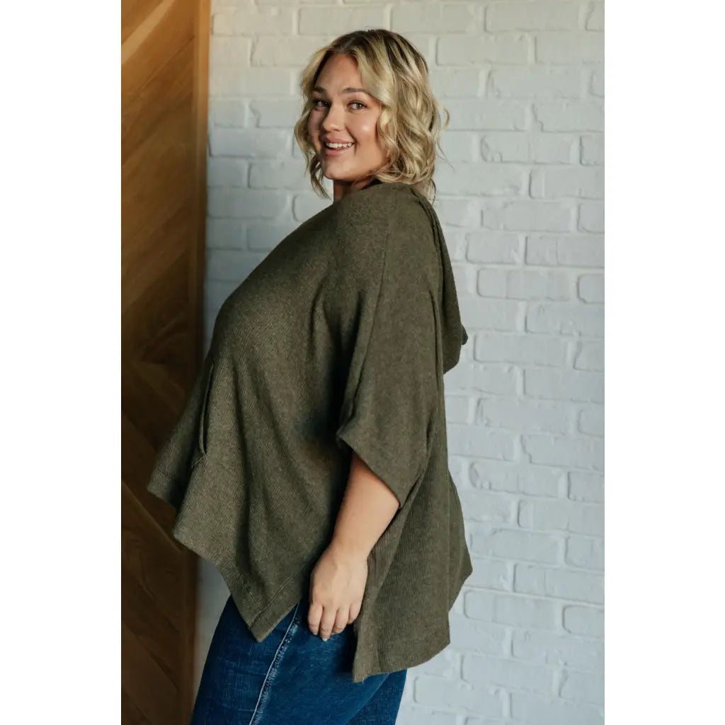 Our Perfectly Poised Hooded Poncho is crafted from a soft olive lightweight and stretchy. ribbed jersey knit.