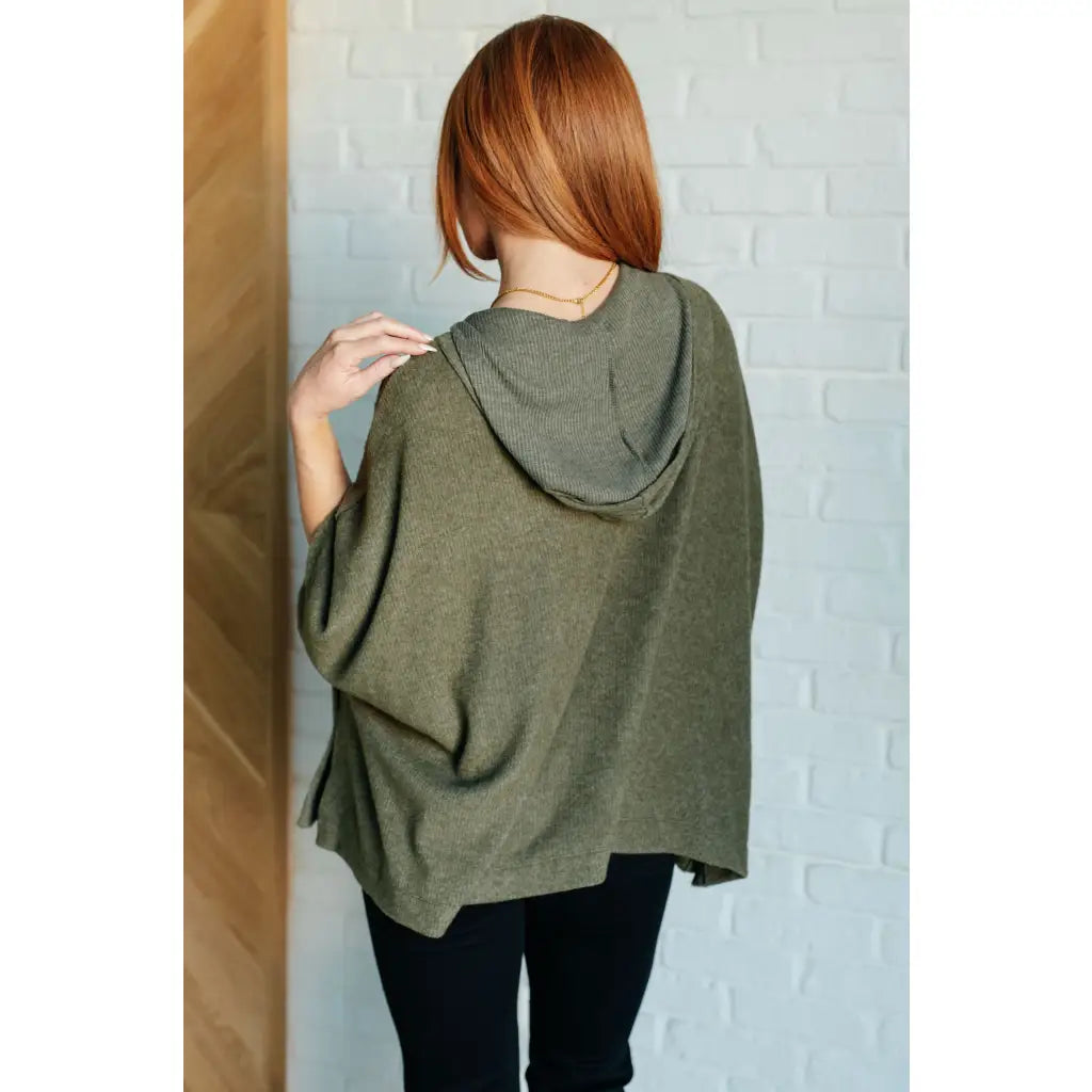 Our Perfectly Poised Hooded Poncho is crafted from a soft olive lightweight and stretchy. ribbed jersey knit.