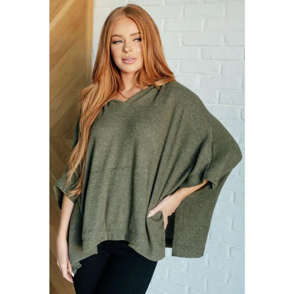 Our Perfectly Poised Hooded Poncho is crafted from a soft olive lightweight and stretchy. ribbed jersey knit.