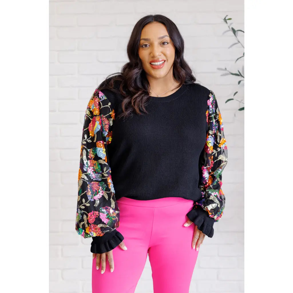 She is the Party Floral Sequins Mesh Sleeve Top brings sparkle! The black ribbed knit and banded round neckline create
