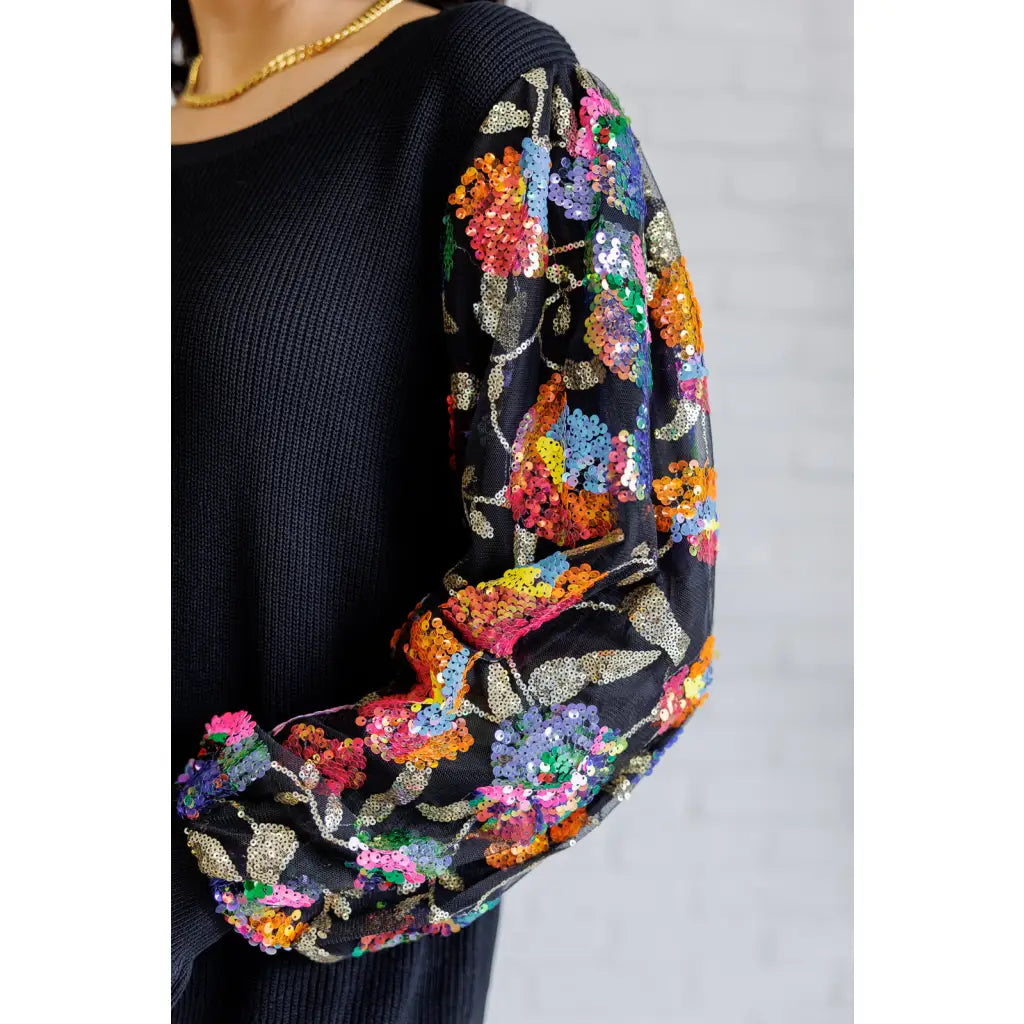 She is the Party Floral Sequins Mesh Sleeve Top brings sparkle! The black ribbed knit and banded round neckline create