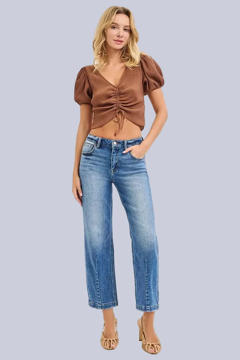 Model wearing Café Chic High Rise Cropped Boyfriend RISEN Jeans in a medium wash with a relaxed cropped boyfriend fit.