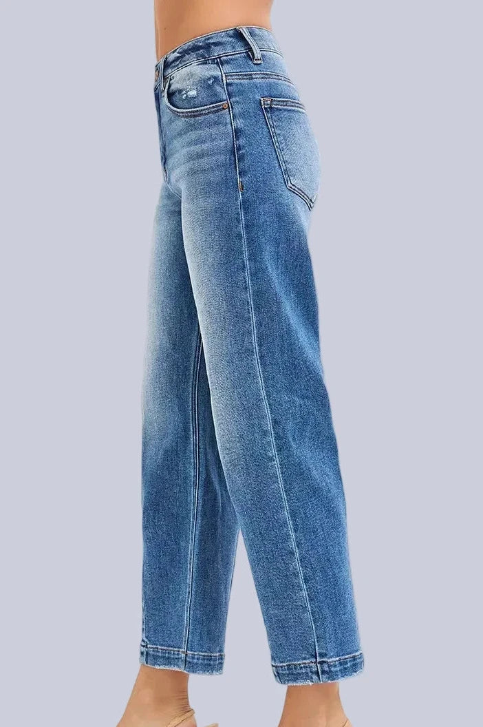 Model wearing Café Chic High Rise Cropped Boyfriend RISEN Jeans in a medium wash with a relaxed cropped boyfriend fit.