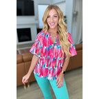 Show your bold side in the Abstract Art V-Neck Blouse plus. Hot pink magenta teal and white make it a standout.
