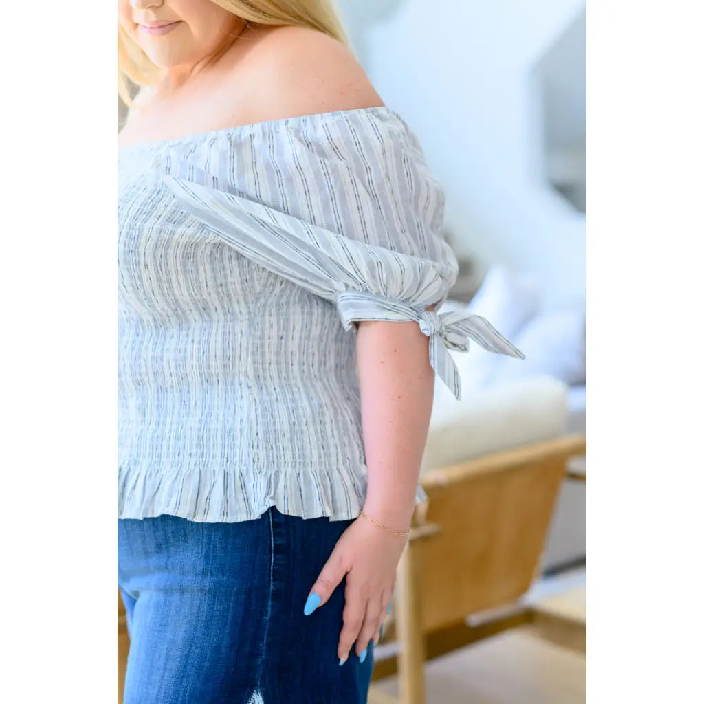 Shop the Serenity in Stripes Smocked Top. Blue and white cotton smocked fit puff sleeves boutique chic. Available