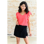 Shop our Coral Pink Ruffle Sleeve Top! Feminine flutter sleeves back tie detail and easy fit for everyday style.