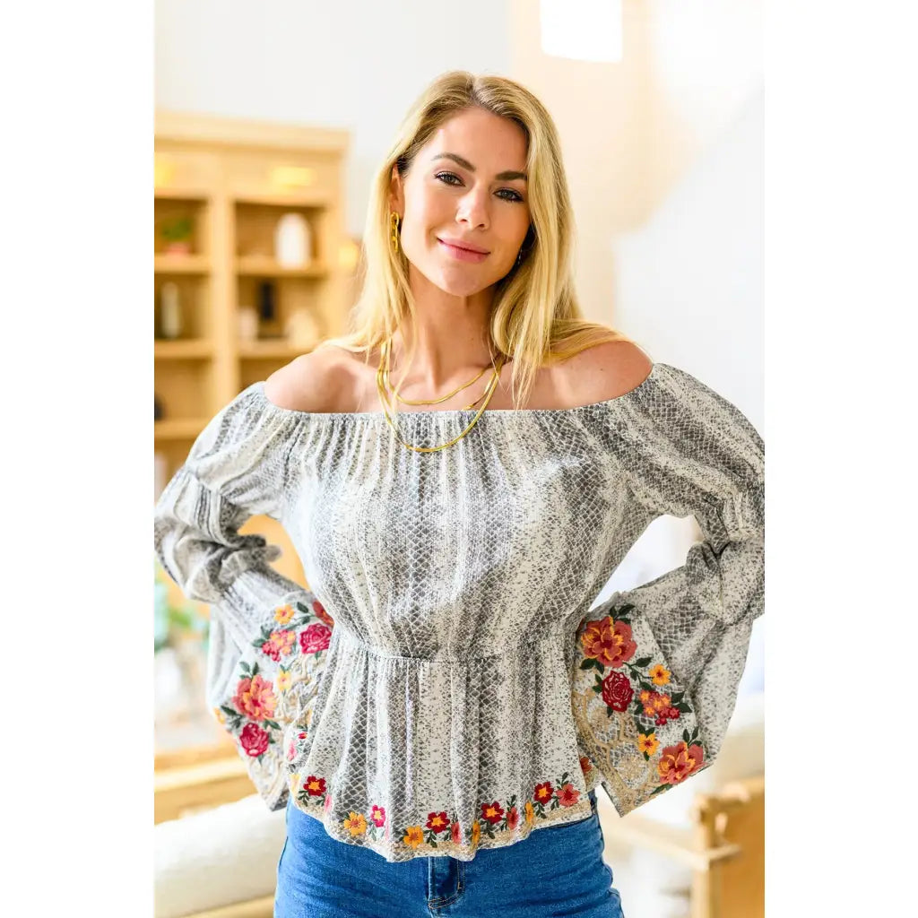 Fashioned with bold snake print and exquisite floral embroidery our Don’t Tempt Me Blouse delivers an irresistible