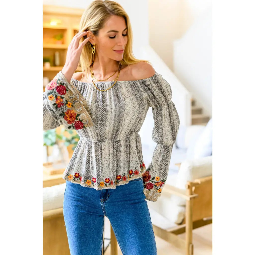 Fashioned with bold snake print and exquisite floral embroidery our Don’t Tempt Me Blouse delivers an irresistible