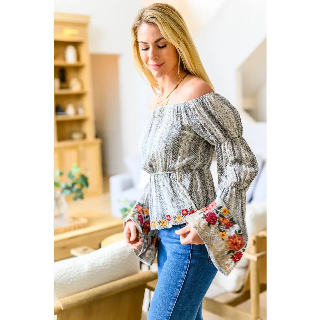 Fashioned with bold snake print and exquisite floral embroidery our Don’t Tempt Me Blouse delivers an irresistible