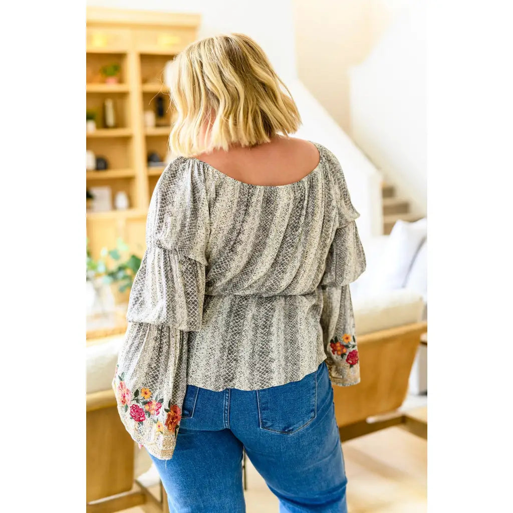 Fashioned with bold snake print and exquisite floral embroidery our Don’t Tempt Me Blouse delivers an irresistible