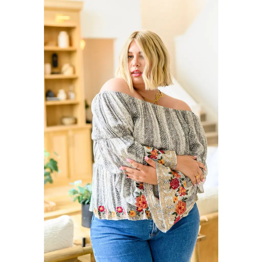 Fashioned with bold snake print and exquisite floral embroidery our Don’t Tempt Me Blouse delivers an irresistible