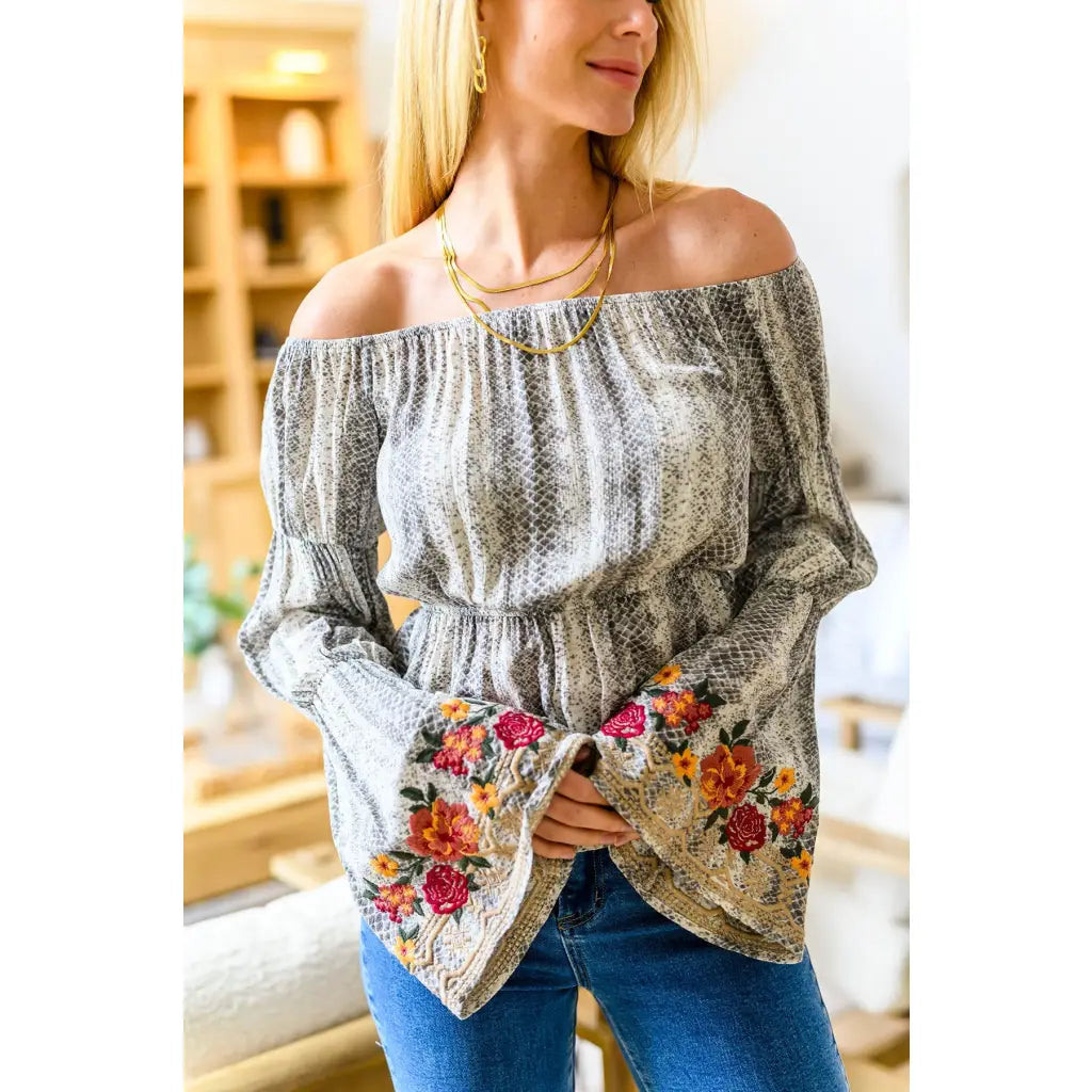 Fashioned with bold snake print and exquisite floral embroidery our Don’t Tempt Me Blouse delivers an irresistible