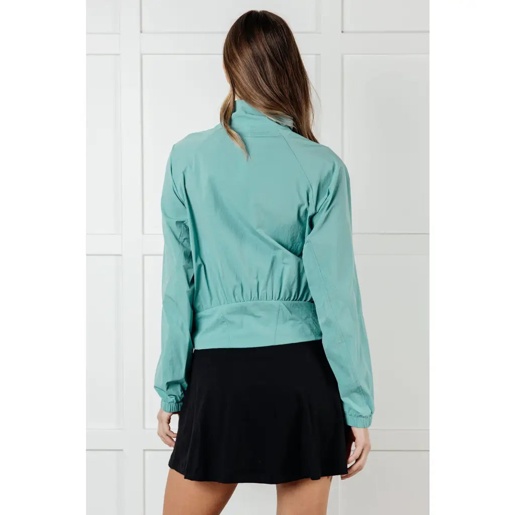 Keep your serve stylish with our Fit Happens Nylon Tennis Jacket in Teal. The high neckline and bubble gathered detail