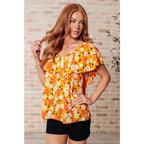 Shop our Freshly Picked Orange Floral Top featuring ruffle cap sleeves & a flattering V-neckline. Plus it’s available