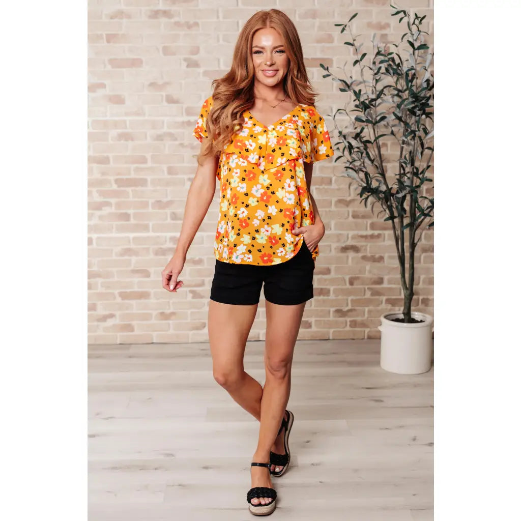 Shop our Freshly Picked Orange Floral Top featuring ruffle cap sleeves & a flattering V-neckline. Plus it’s available