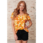 Shop our Freshly Picked Orange Floral Top featuring ruffle cap sleeves & a flattering V-neckline. Plus it’s available