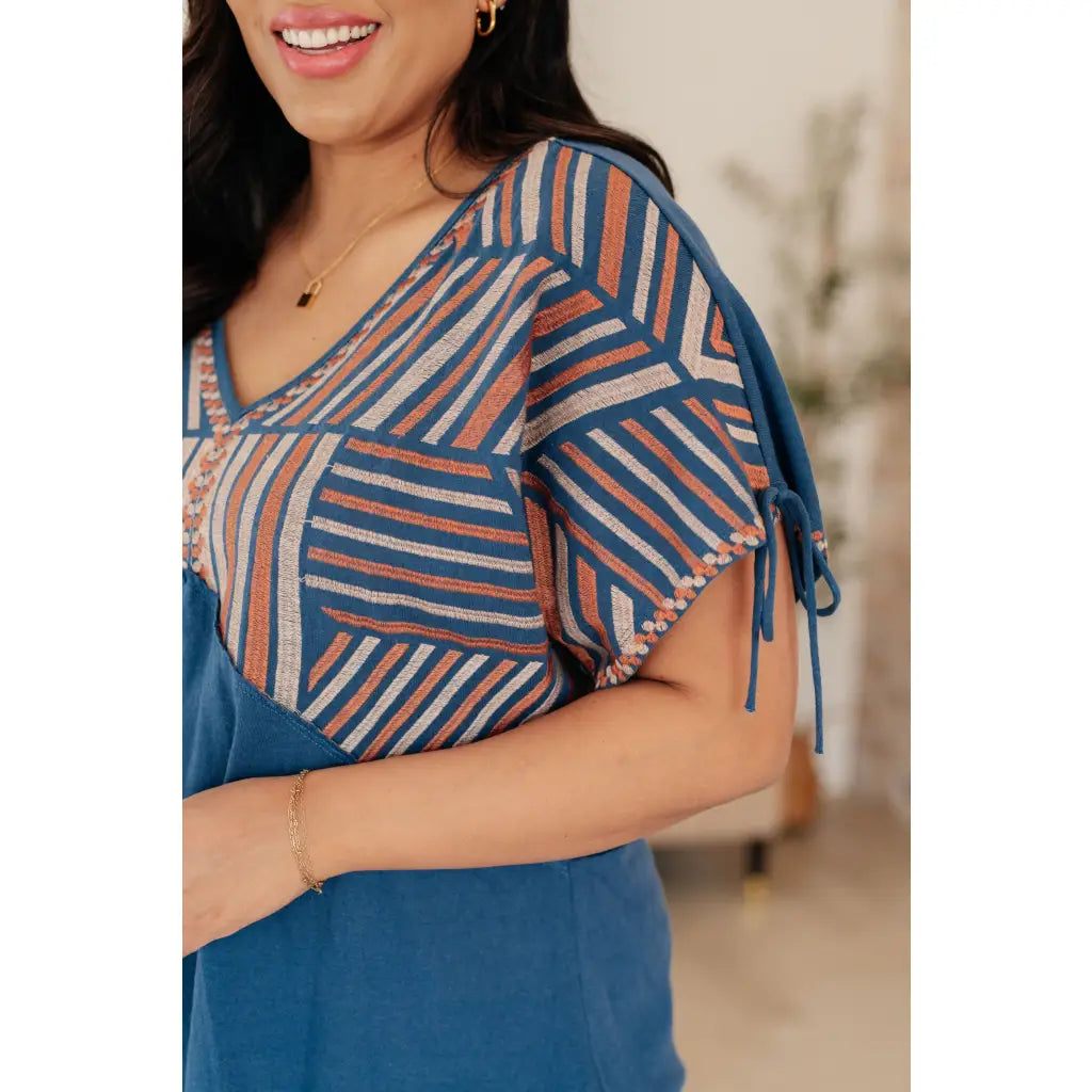 Get ready to strike a stylish pose with our Greece Lightning V Neck Blouse! Made from comfortable jersey knit