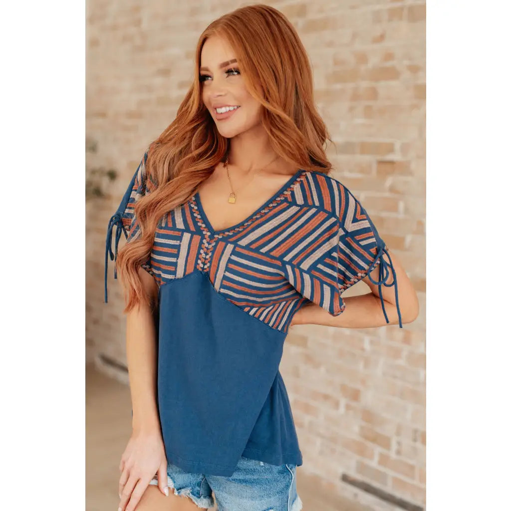 Get ready to strike a stylish pose with our Greece Lightning V Neck Blouse! Made from comfortable jersey knit