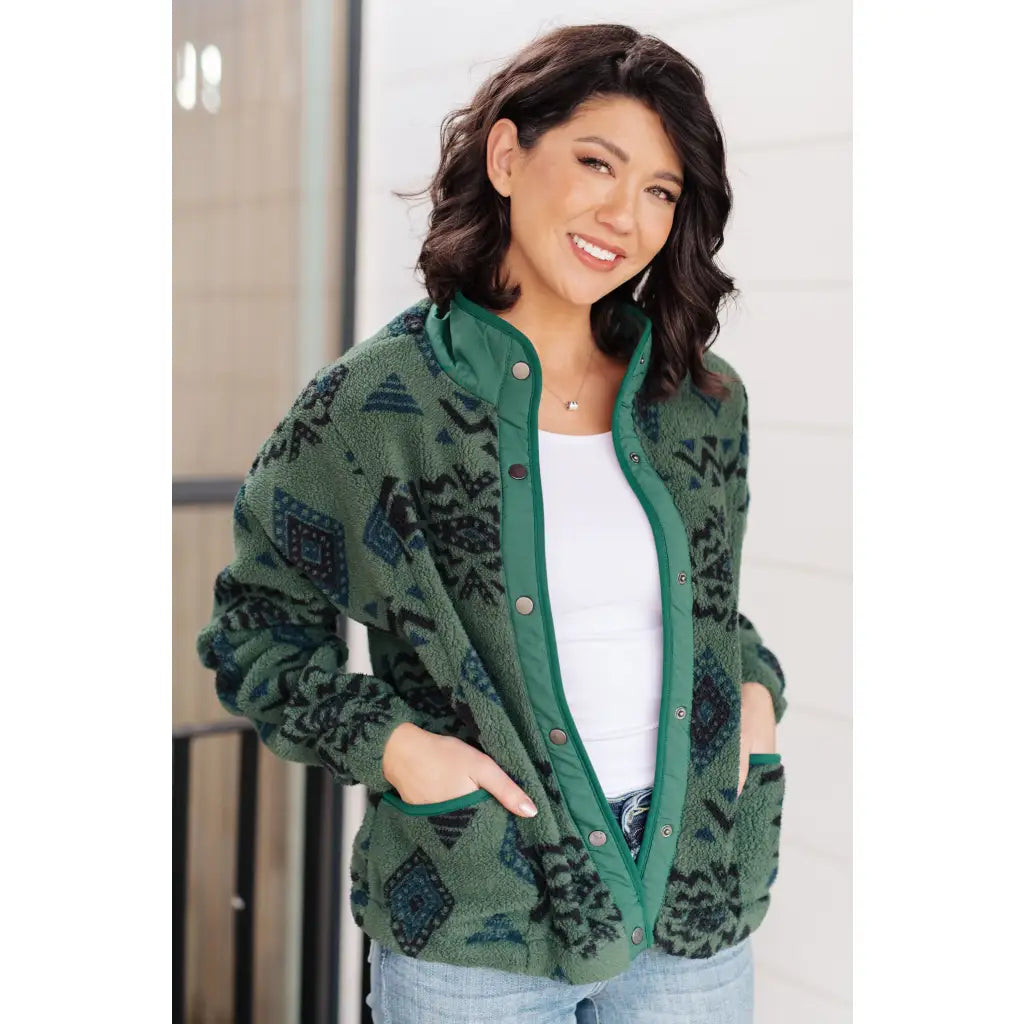 Our High Perspective Geometric Fleece Jacket! Made with green and black soft polar fleece featuring a snap front