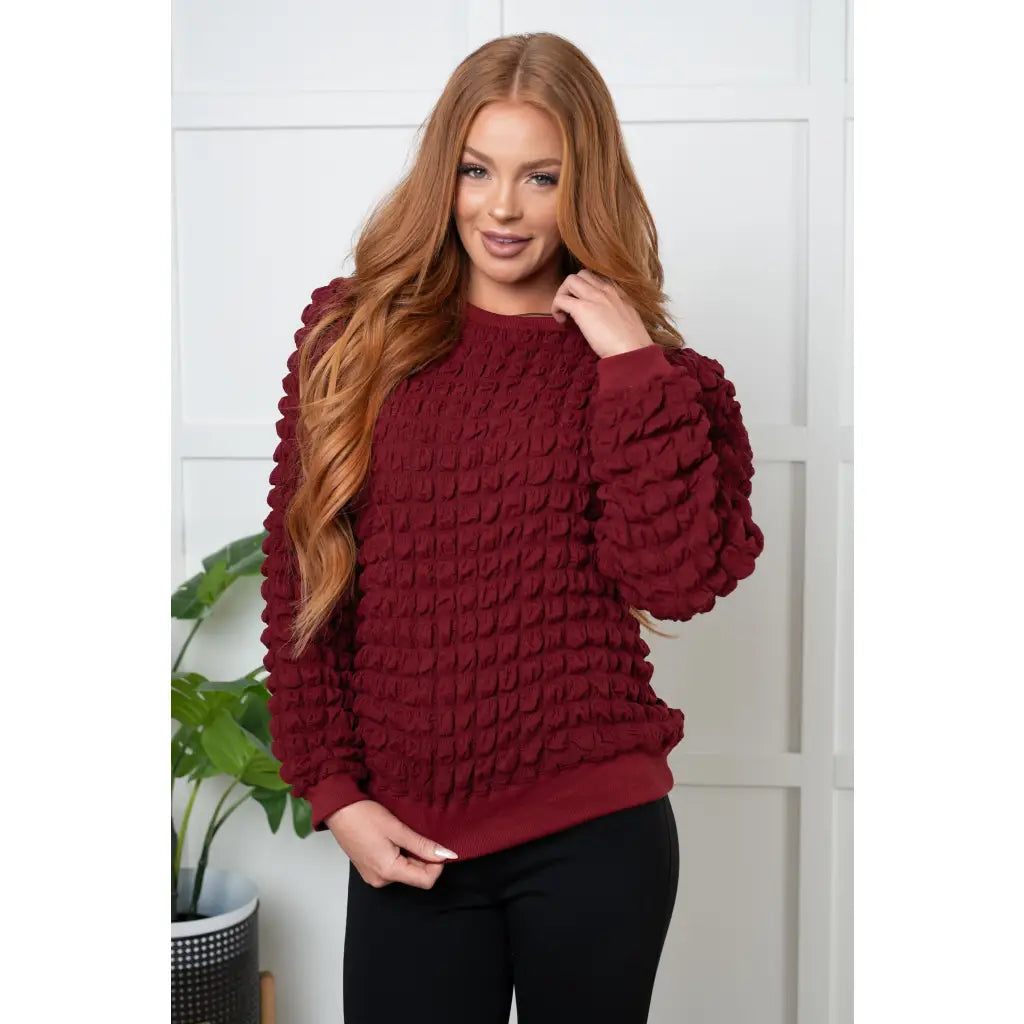 Our In Denial Bubble Pullover Top in Maroon will elevate any wardrobe! Showcase your trendy style with the shoulder