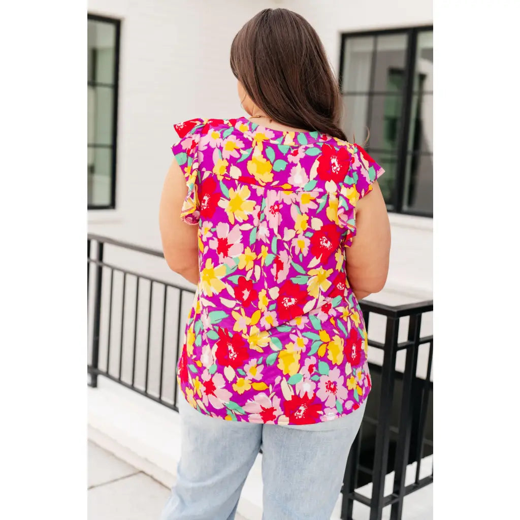 Add some flair to your wardrobe with our Lizzy Flutter Sleeve Top! This playful and bright magenta yellow floral top