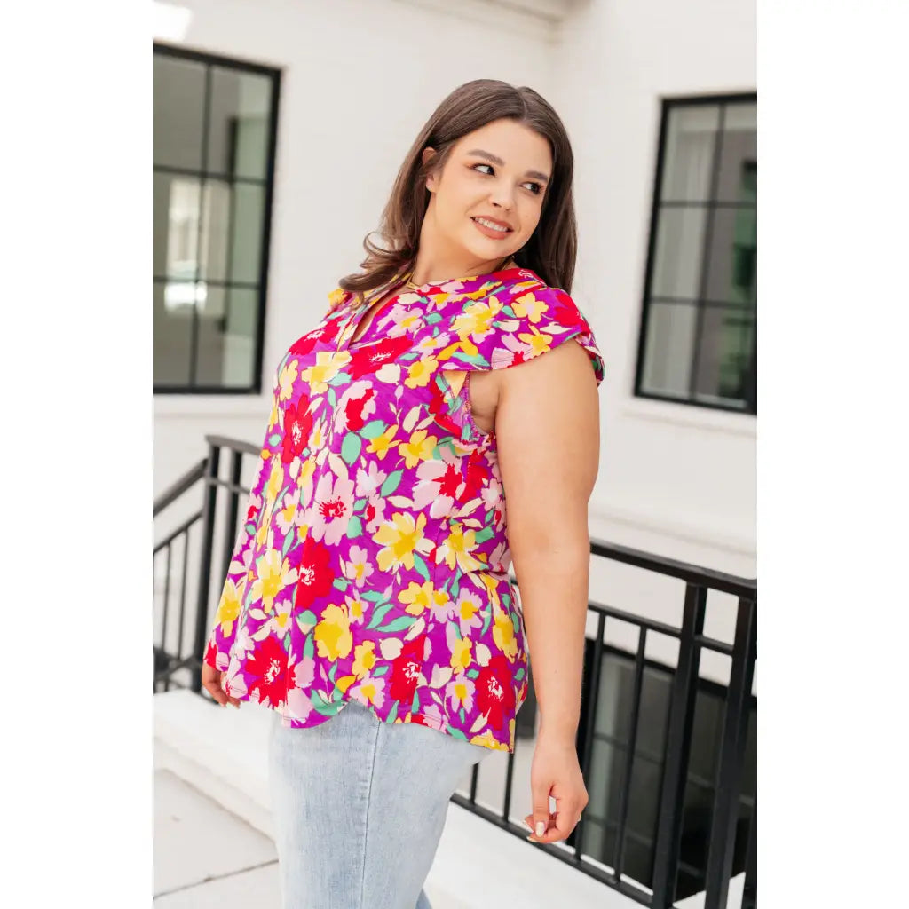 Add some flair to your wardrobe with our Lizzy Flutter Sleeve Top! This playful and bright magenta yellow floral top