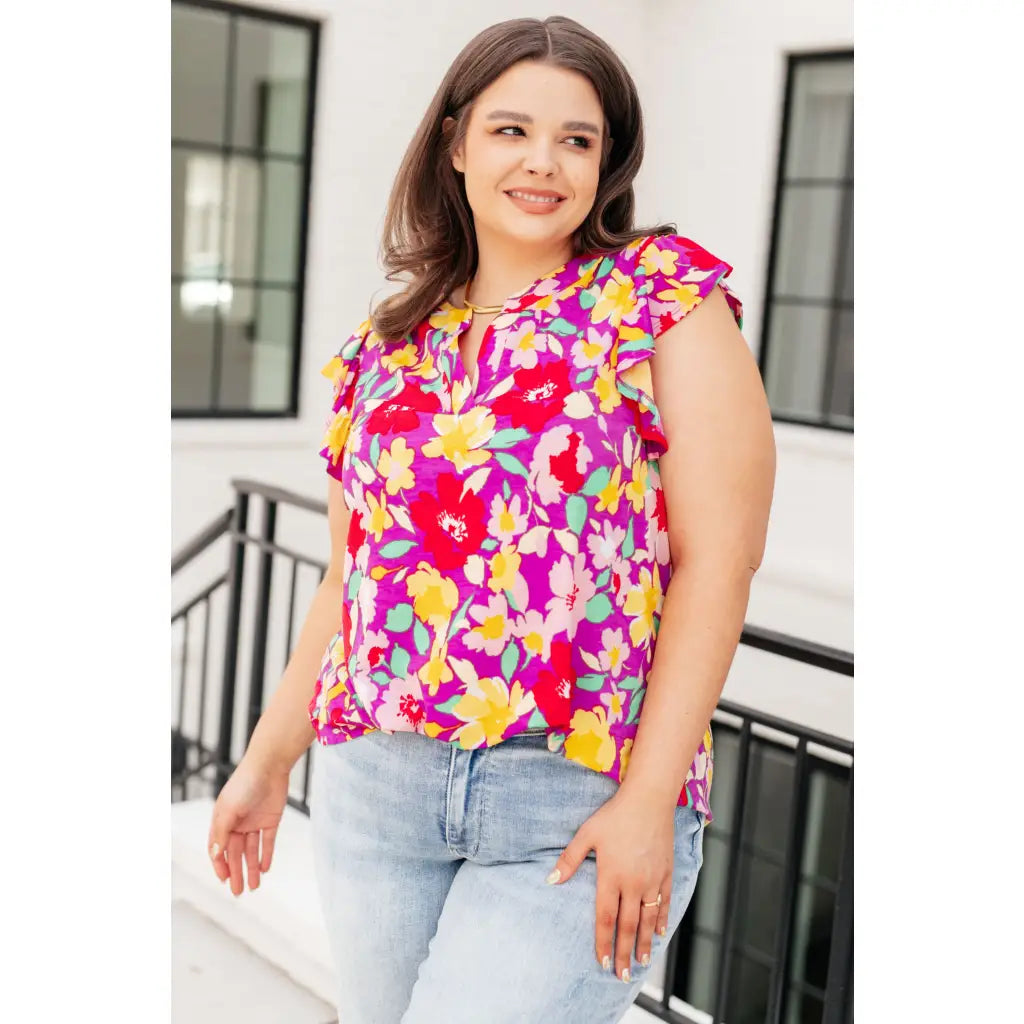 Add some flair to your wardrobe with our Lizzy Flutter Sleeve Top! This playful and bright magenta yellow floral top