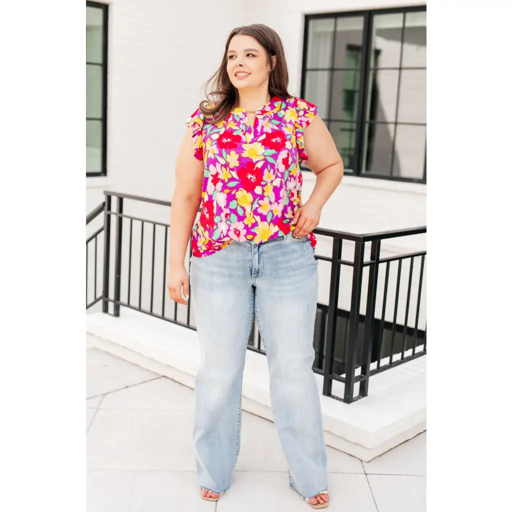 Add some flair to your wardrobe with our Lizzy Flutter Sleeve Top! This playful and bright magenta yellow floral top