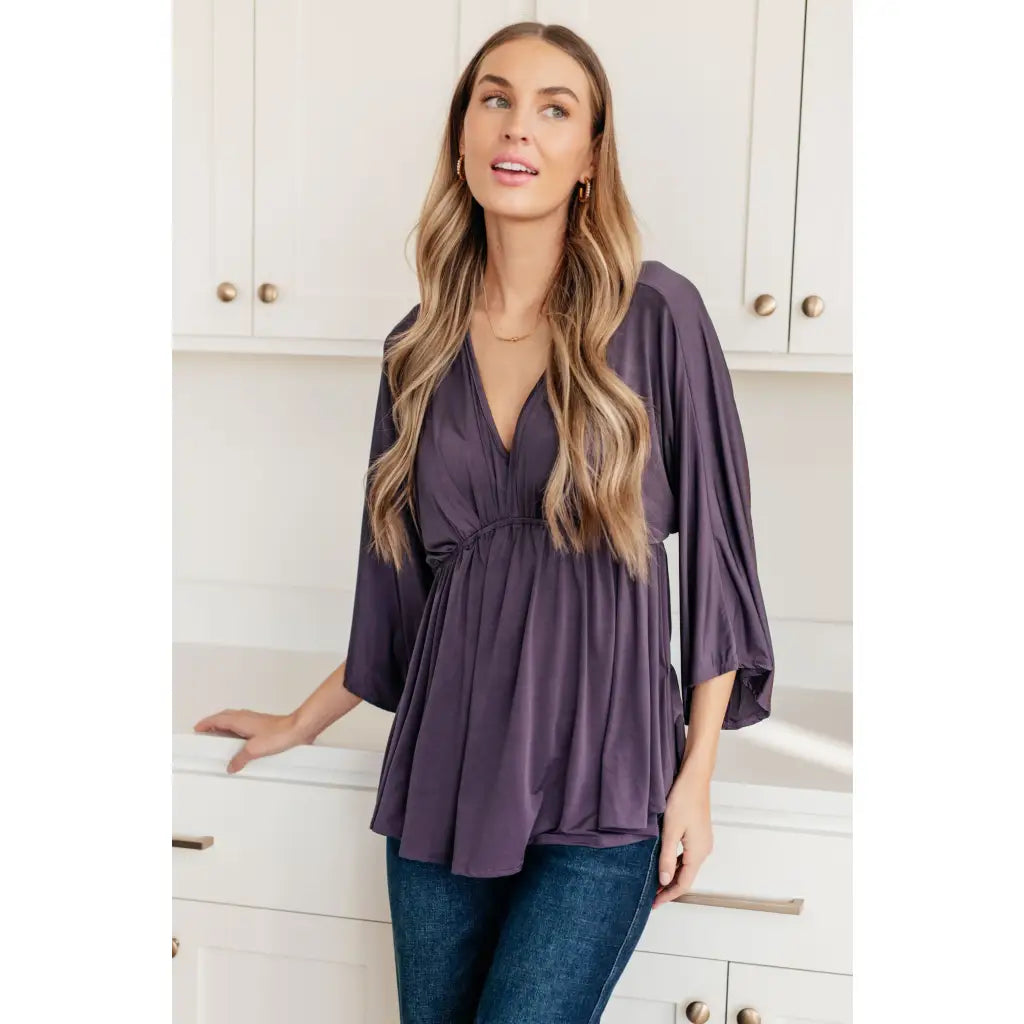 Switch up your wardrobe with this Love On The Line Purple Peplum Blouse! Made from a slinky knit beautiful purple