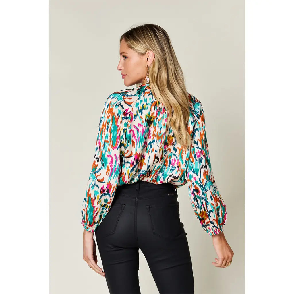 Chic abstract print tunic blouse with flowy fit and ruffled neckline. Sizes SM–3XL. Perfect plus size office top