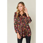Chic abstract print tunic blouse with flowy fit and ruffled neckline. Sizes SM–3XL. Perfect plus size office top