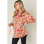 Chic abstract print tunic blouse with flowy fit and ruffled neckline. Sizes SM–3XL. Perfect plus size office top