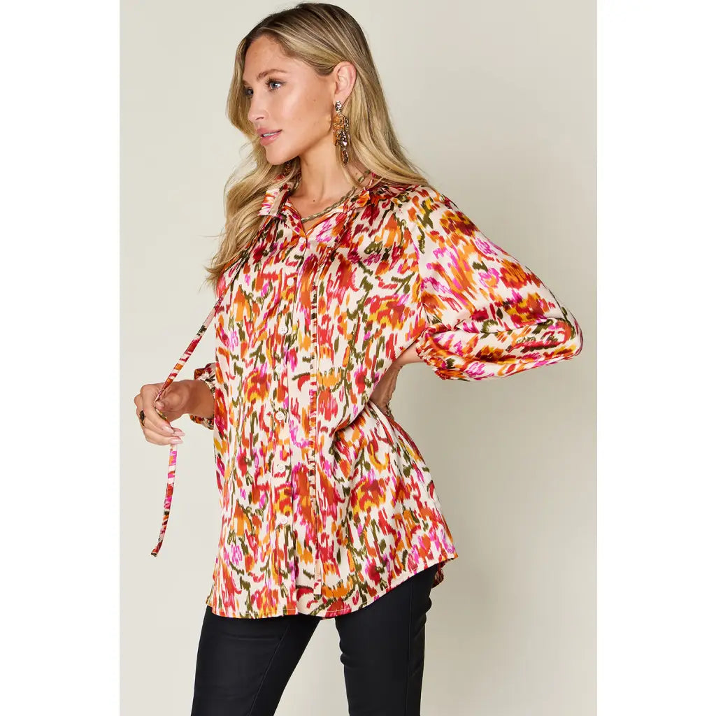 Chic abstract print tunic blouse with flowy fit and ruffled neckline. Sizes SM–3XL. Perfect plus size office top