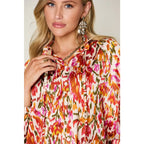 Chic abstract print tunic blouse with flowy fit and ruffled neckline. Sizes SM–3XL. Perfect plus size office top