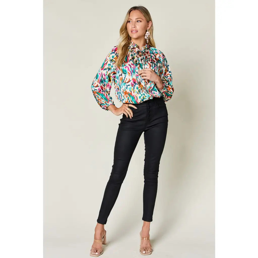 Chic abstract print tunic blouse with flowy fit and ruffled neckline. Sizes SM–3XL. Perfect plus size office top