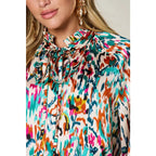 Chic abstract print tunic blouse with flowy fit and ruffled neckline. Sizes SM–3XL. Perfect plus size office top