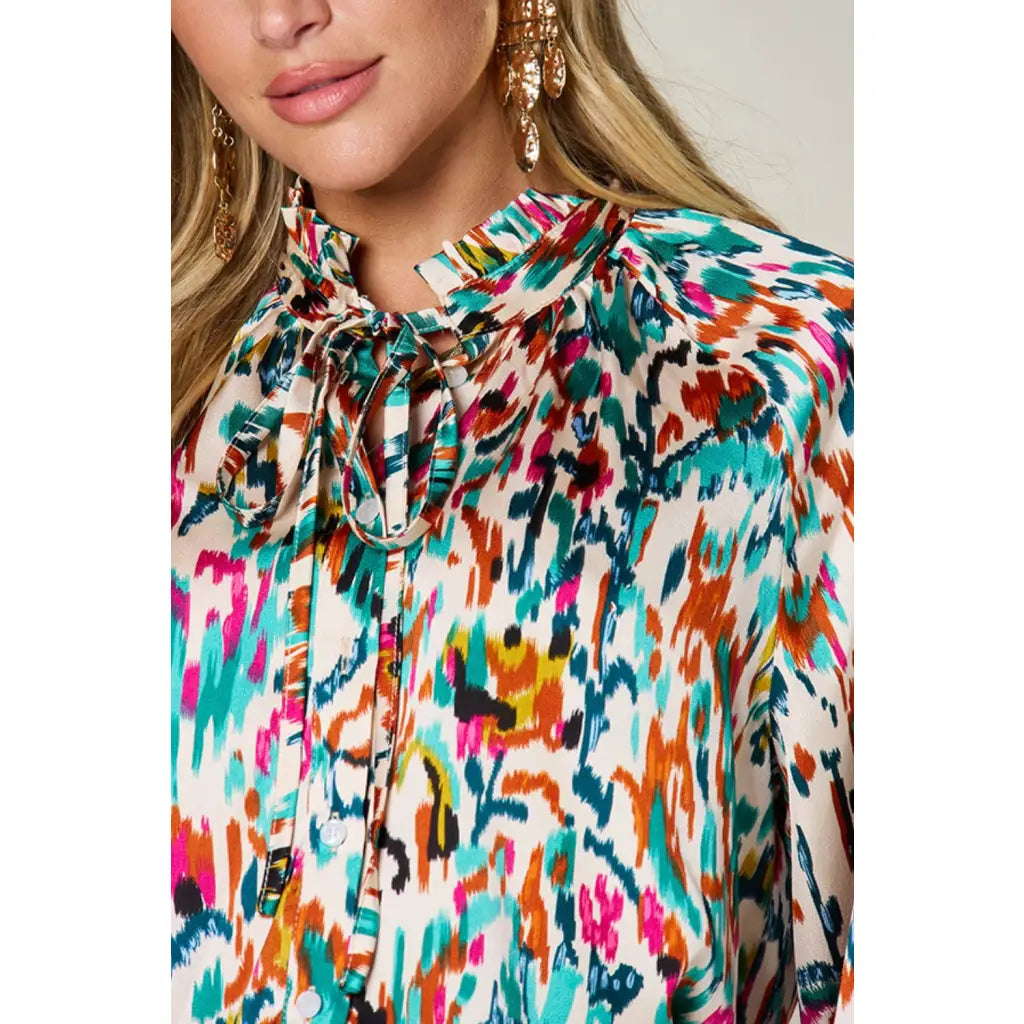Chic abstract print tunic blouse with flowy fit and ruffled neckline. Sizes SM–3XL. Perfect plus size office top