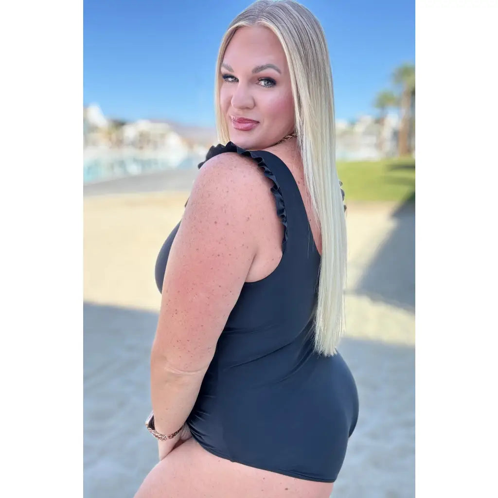 Chic black one-piece swimsuit with ruffle straps v-neckline ruching and removable cups. Plus size swimwear