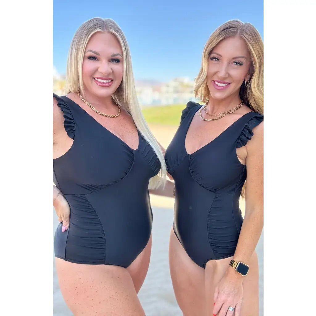 Chic black one-piece swimsuit with ruffle straps v-neckline ruching and removable cups. Plus size swimwear