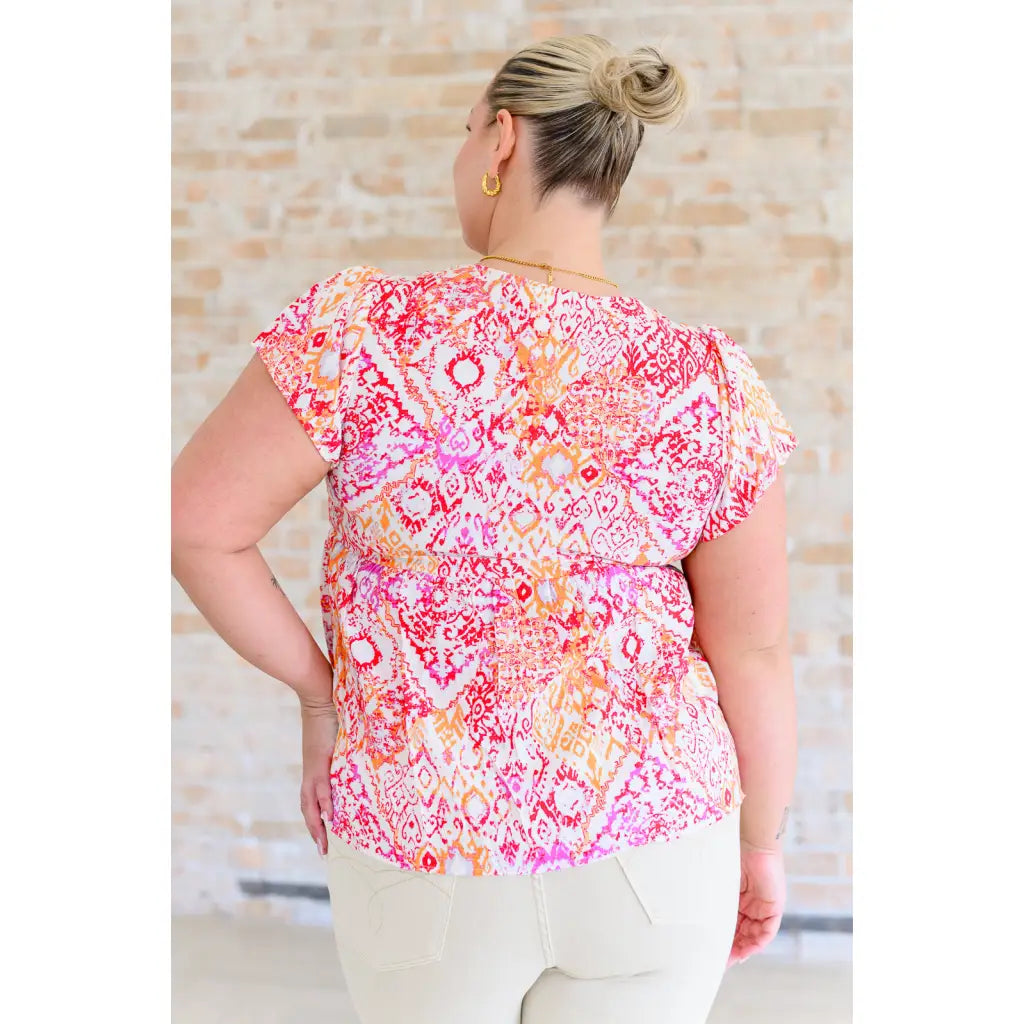 Stay on trend with our A Matter of Time Flutter Sleeve Top in Multi Pink! This woven top features a flattering v