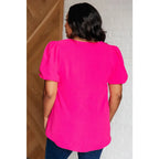 Hot pink puff sleeve blouse with V-neck and flowy fit. Available in standard curvy plus sizes. Lightweight bold &
