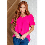 Hot pink puff sleeve blouse with V-neck and flowy fit. Available in standard curvy plus sizes. Lightweight bold &