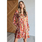 Our Once Upon a Dream Mini Dress features an abstract floral print with flattering v-neckline and billowy cased elastic