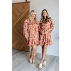 Our Once Upon a Dream Mini Dress features an abstract floral print with flattering v-neckline and billowy cased elastic