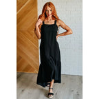 Chic black crinkle maxi dress with pockets ruffle hem and tie back. A flattering essential for effortless everyday