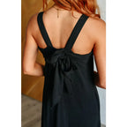 Chic black crinkle maxi dress with pockets ruffle hem and tie back. A flattering essential for effortless everyday