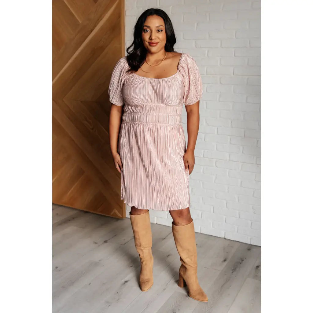 Our Pale Pink Plisse Mini Dress is an adorable little poly satin frock that boasts a cute cased elastic shoulder