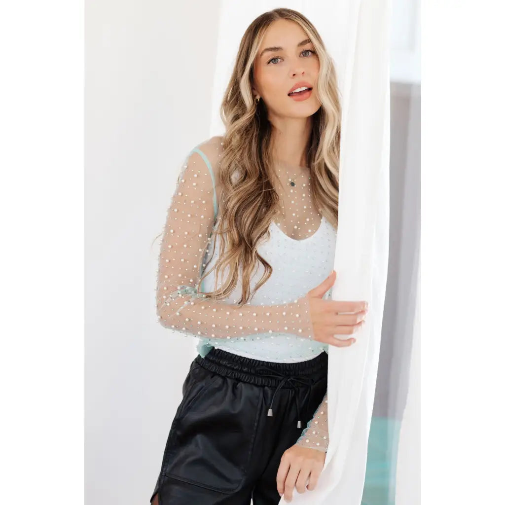 Our Pearl Diver Mesh Layering Top in Light Cyan is a stretchy long sleeve top embellished with faux pearls